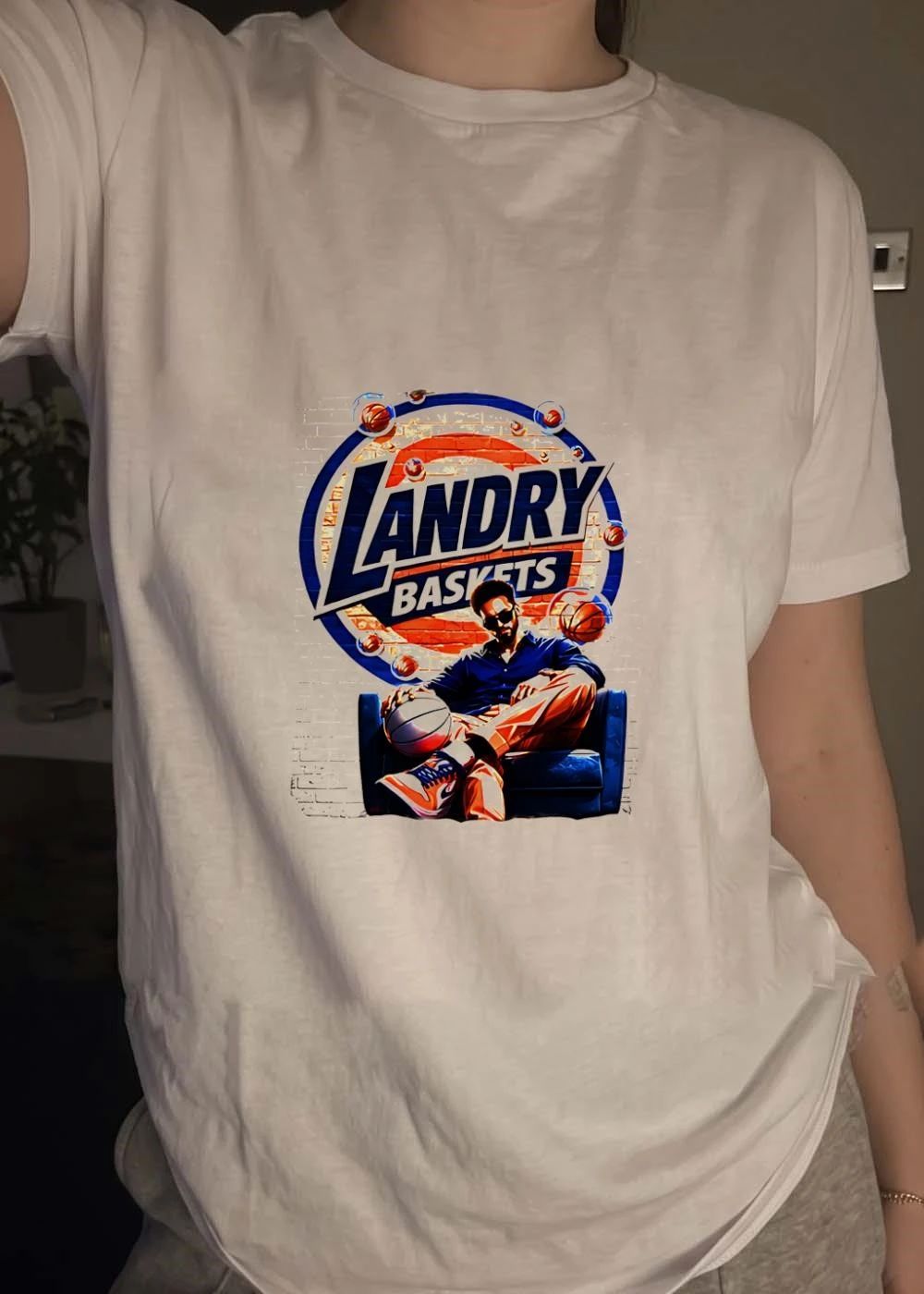 Landry Baskets Stylish Man Sitting with Basketball Graphic T-Shirt
