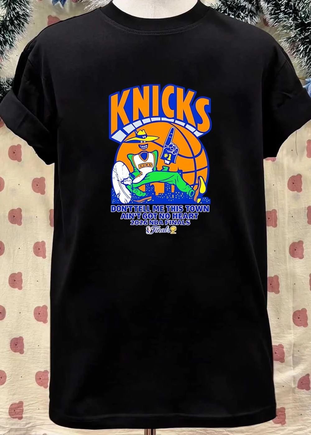 Knicks Apparel ‘ Mascot Holding Foam Finger ‘ Don’t Tell Me This Town Ain’t Got No Heart 2026 NBA Finals Knicks T-Shirt